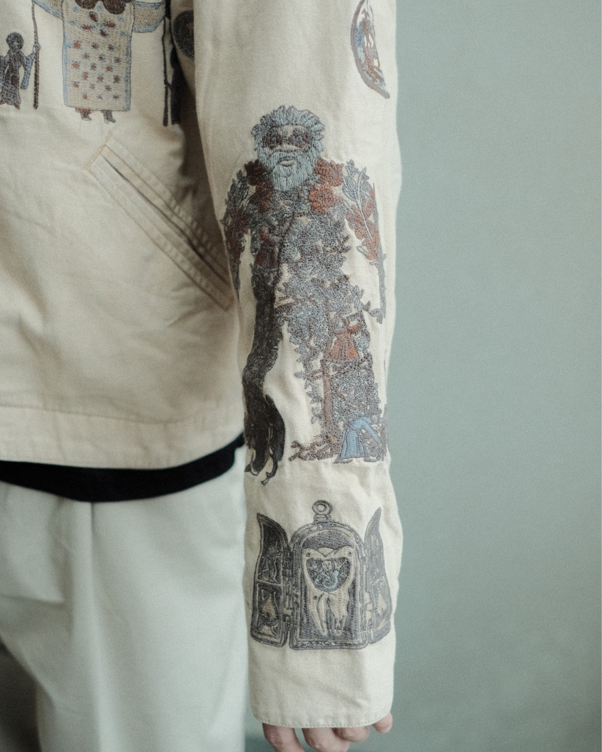 SAMUEL ZELIG Elder Work Jacket Pale Khaki EL-FW26-18-CAN 袖の人物・時計モチーフ刺繍の詳細
